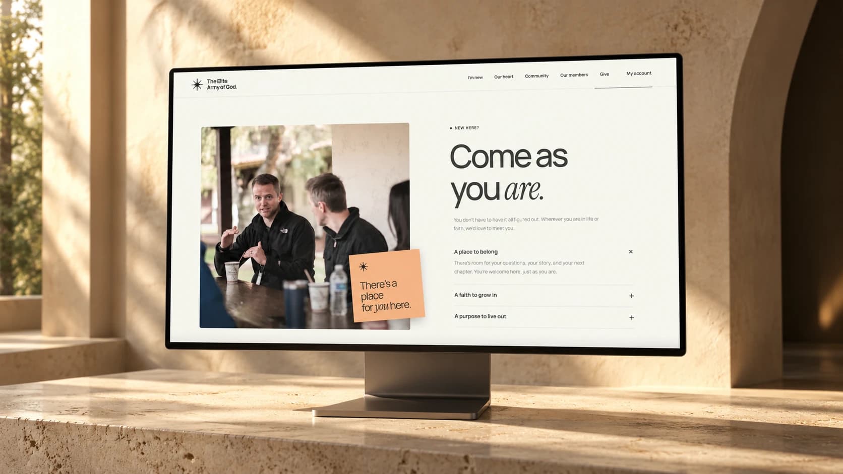 The church welcome page displayed on a desktop monitor in a sunlit architectural setting.